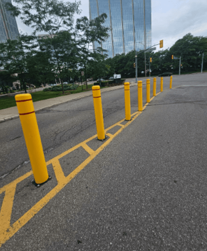 Yellow bollard installation in commercial parking lot