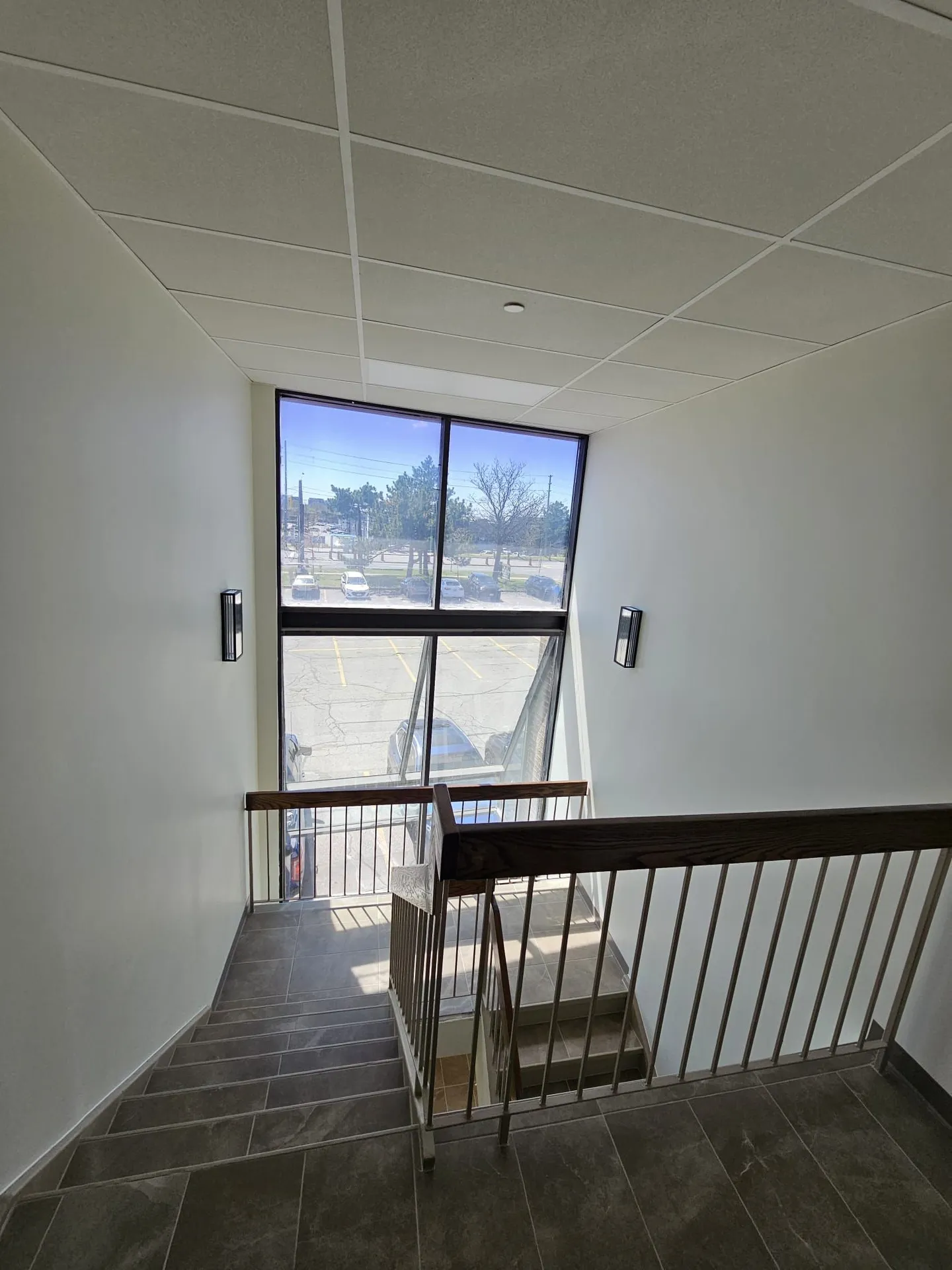 1050 Finch after: finished stairwell landing with full-height window and wall sconces