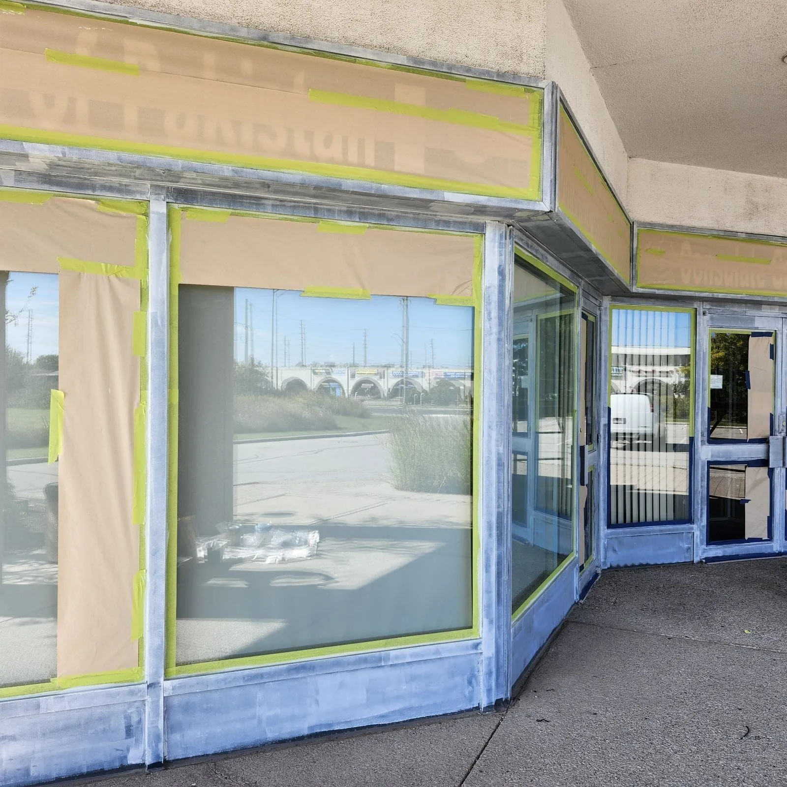 Storefront mid-prep: windows papered and frames primed