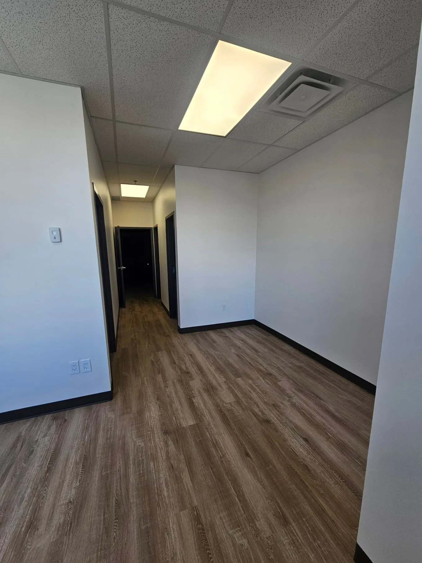 Finished office opening to corridor with new vinyl plank and drop ceiling