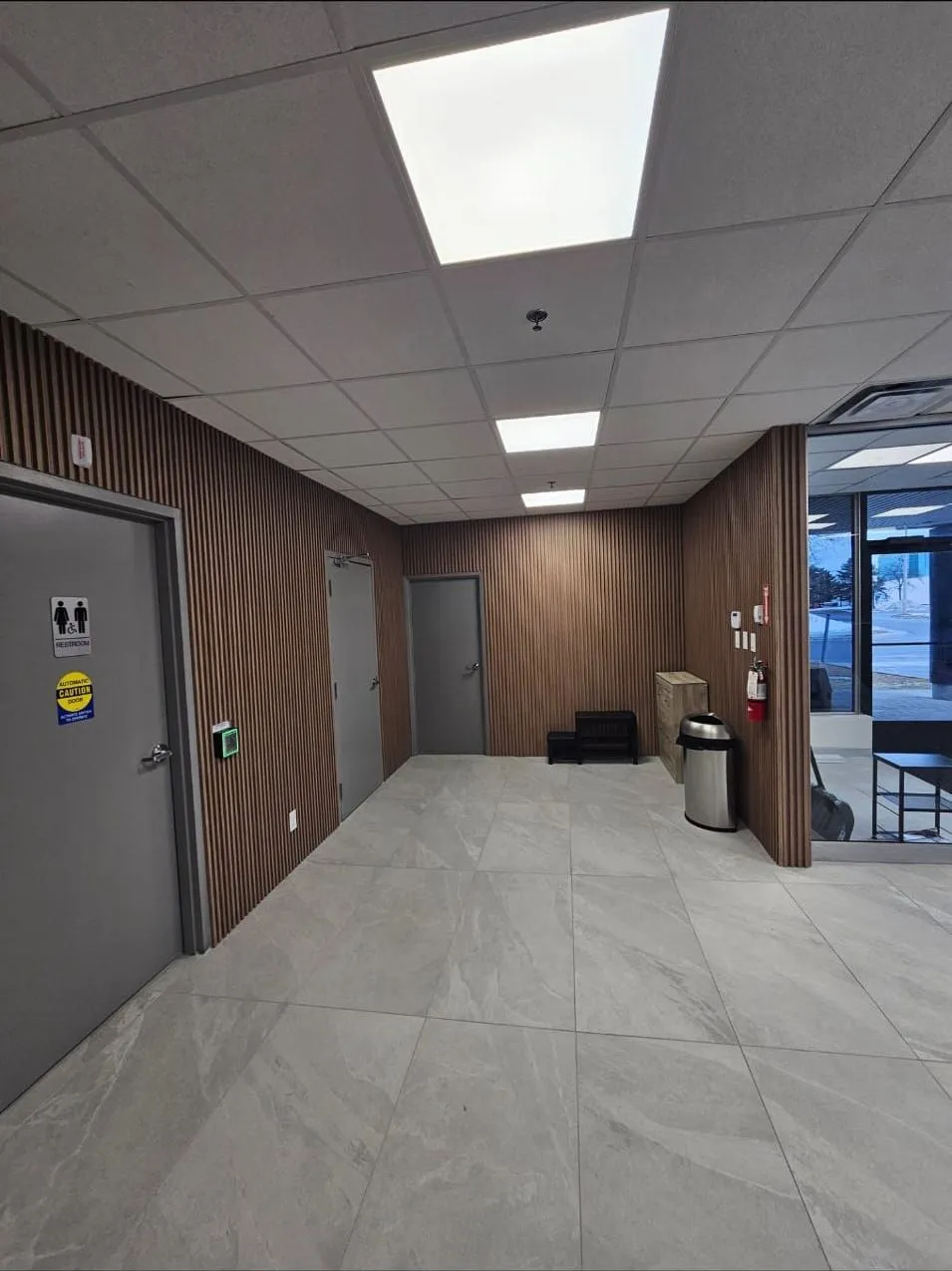 Corridor after: slat-wood feature walls, large-format porcelain tile and new lighting