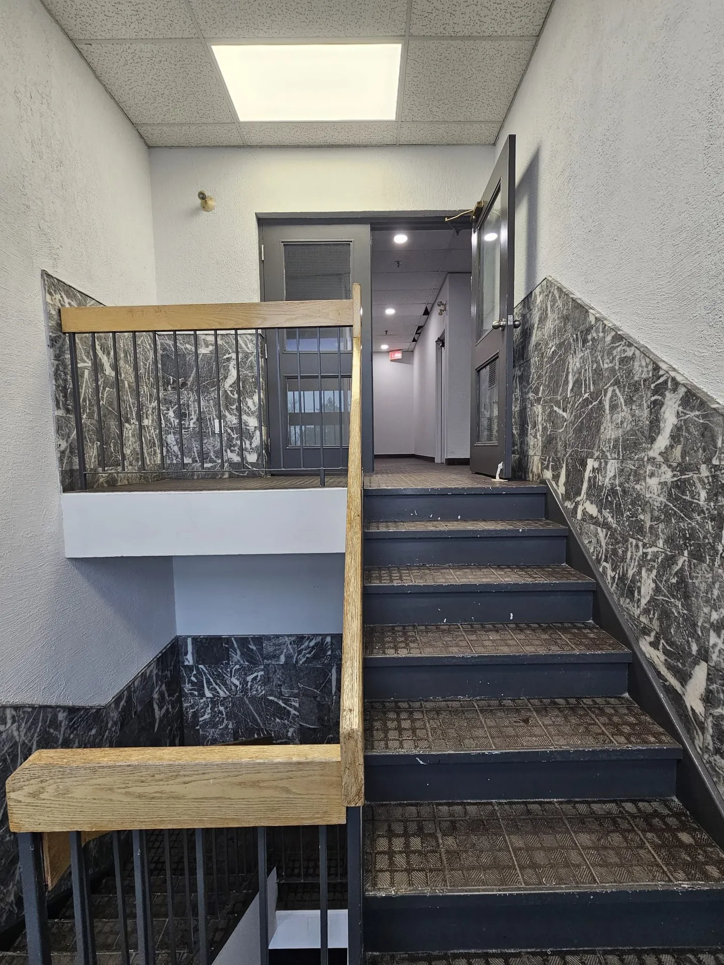 1050 Finch before: original stairwell with black marble wainscot and worn treads