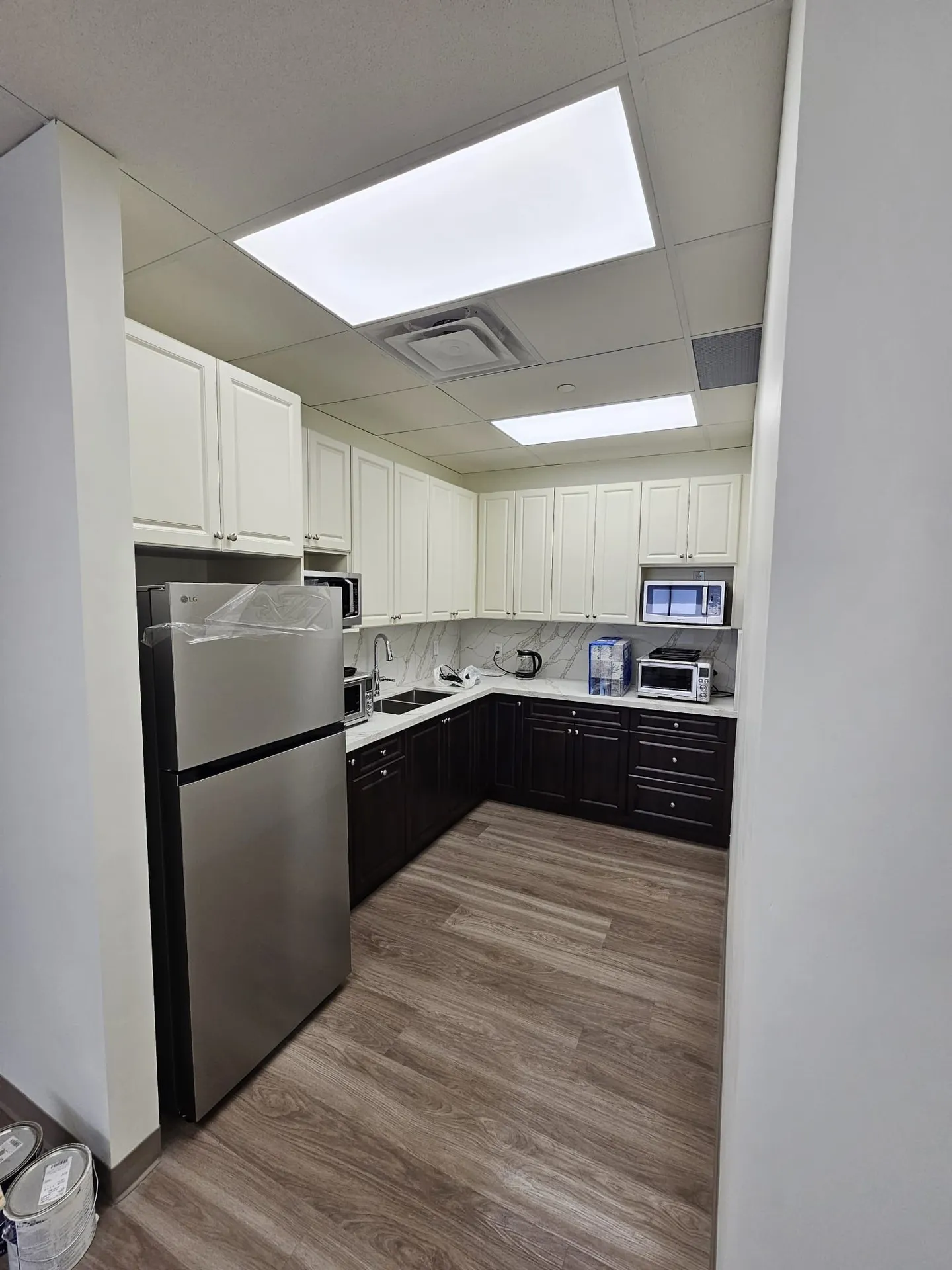 1050 Finch after: finished kitchenette with two-tone cabinetry and tile backsplash