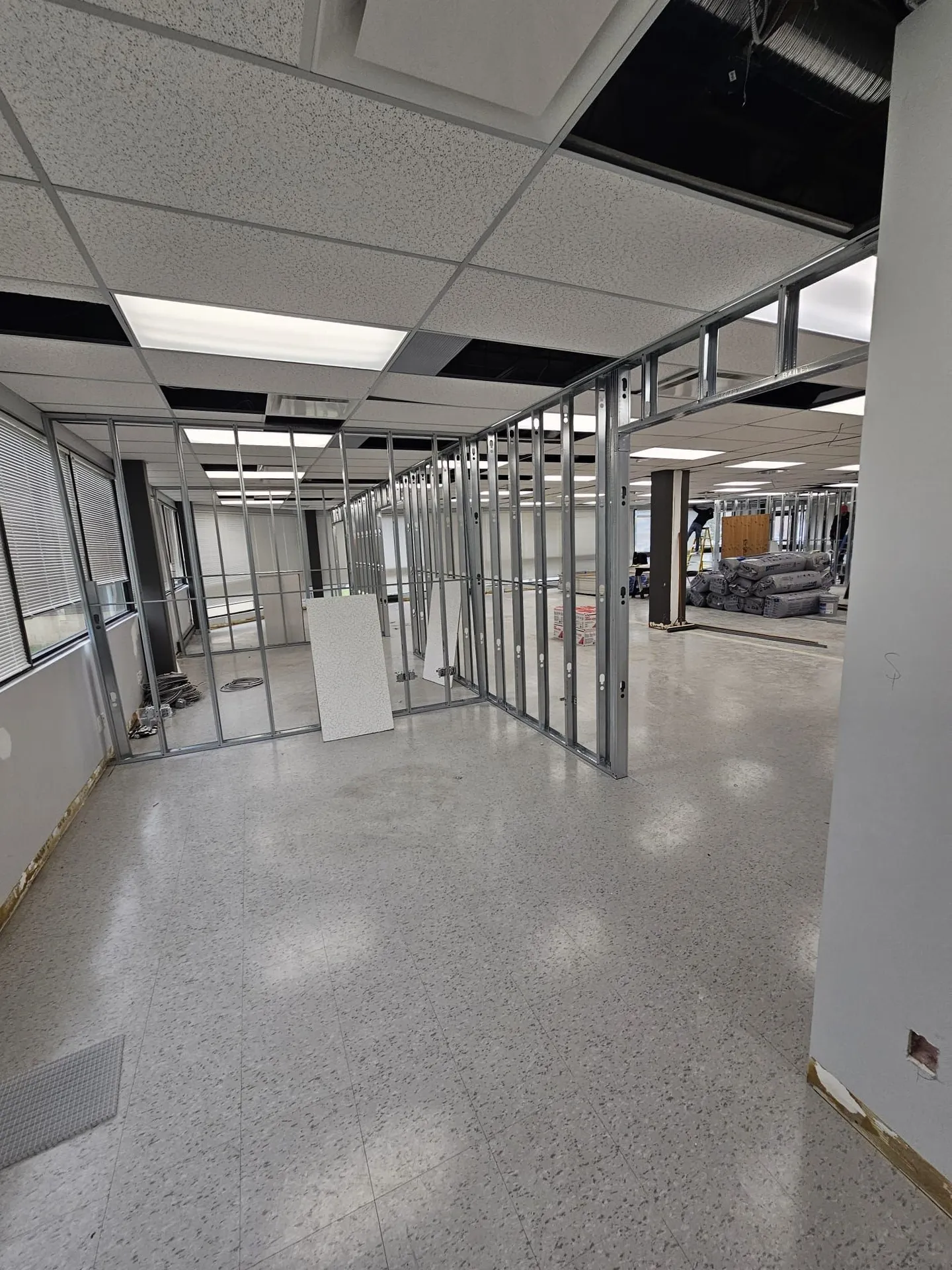 Steel-stud partition framing with drywall boards staged for installation