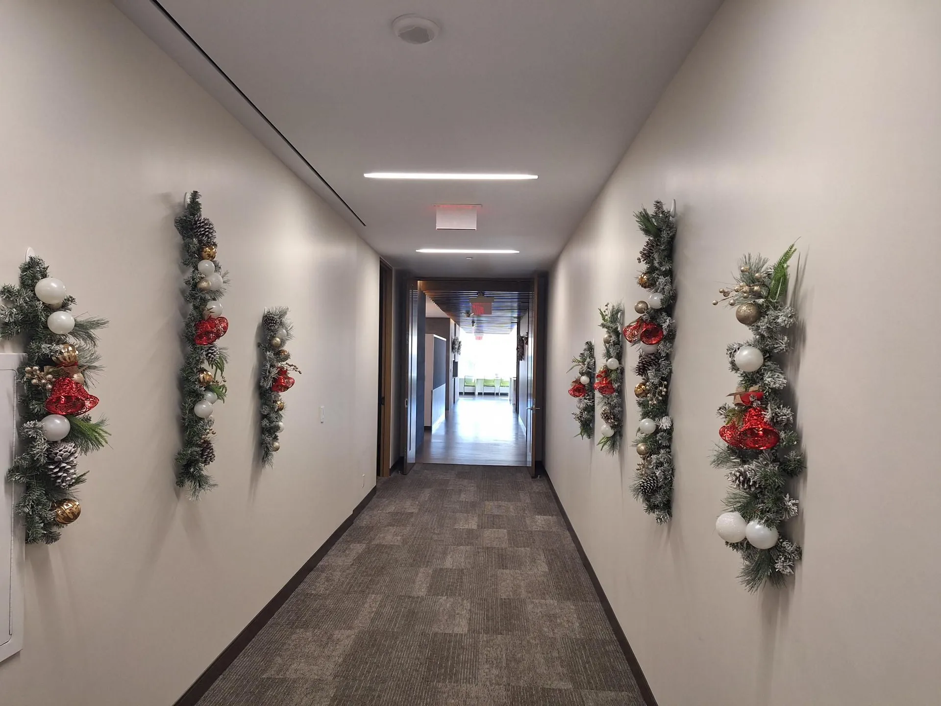 Office corridor dressed with wall-mounted holiday garland swags