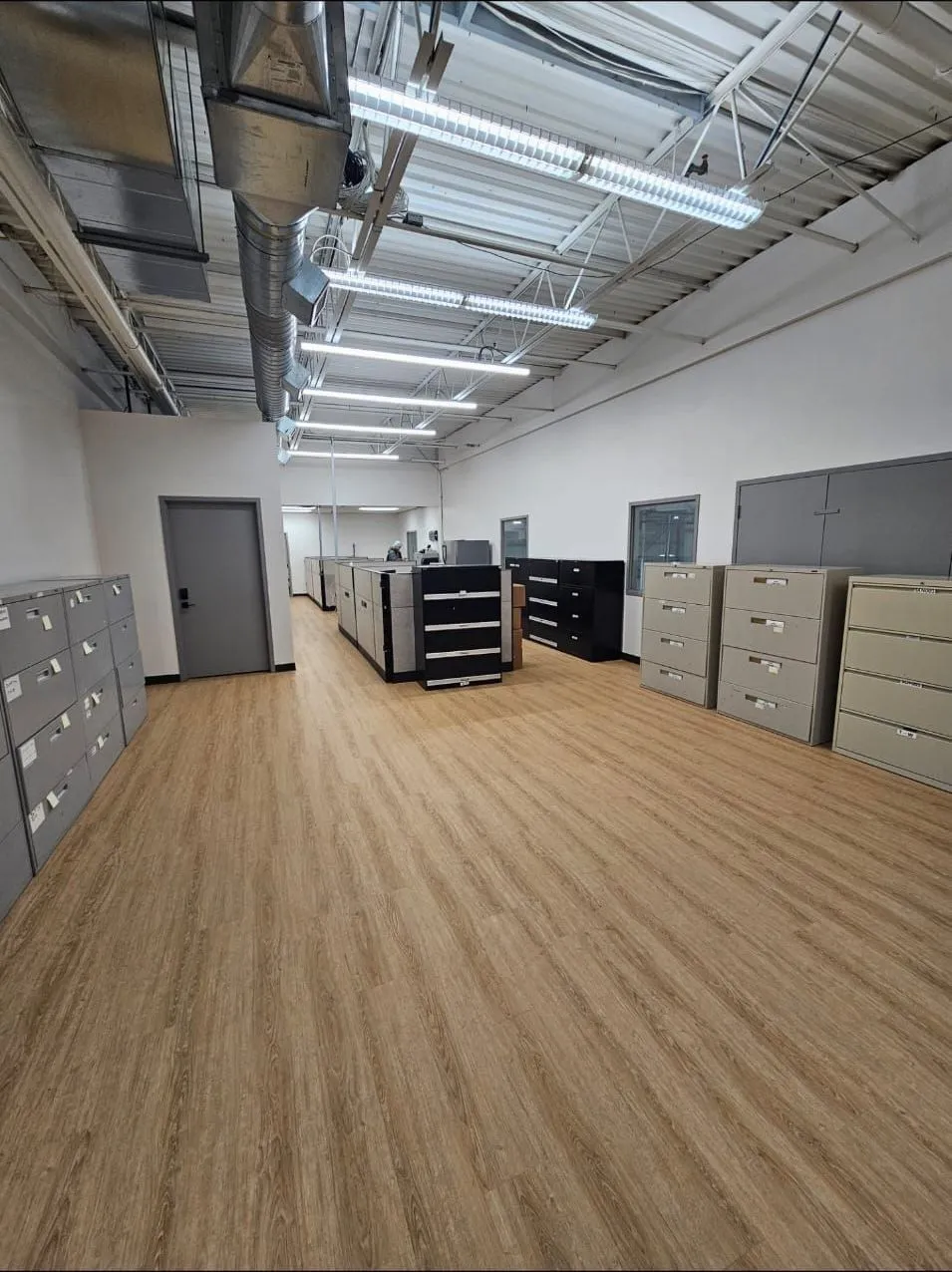 Open office after: new LVP flooring and linear LED lighting on the exposed deck